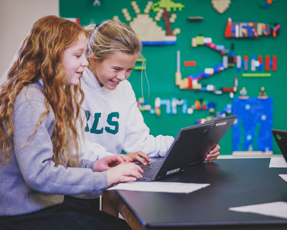 Young female students working on an assignment on a laptop