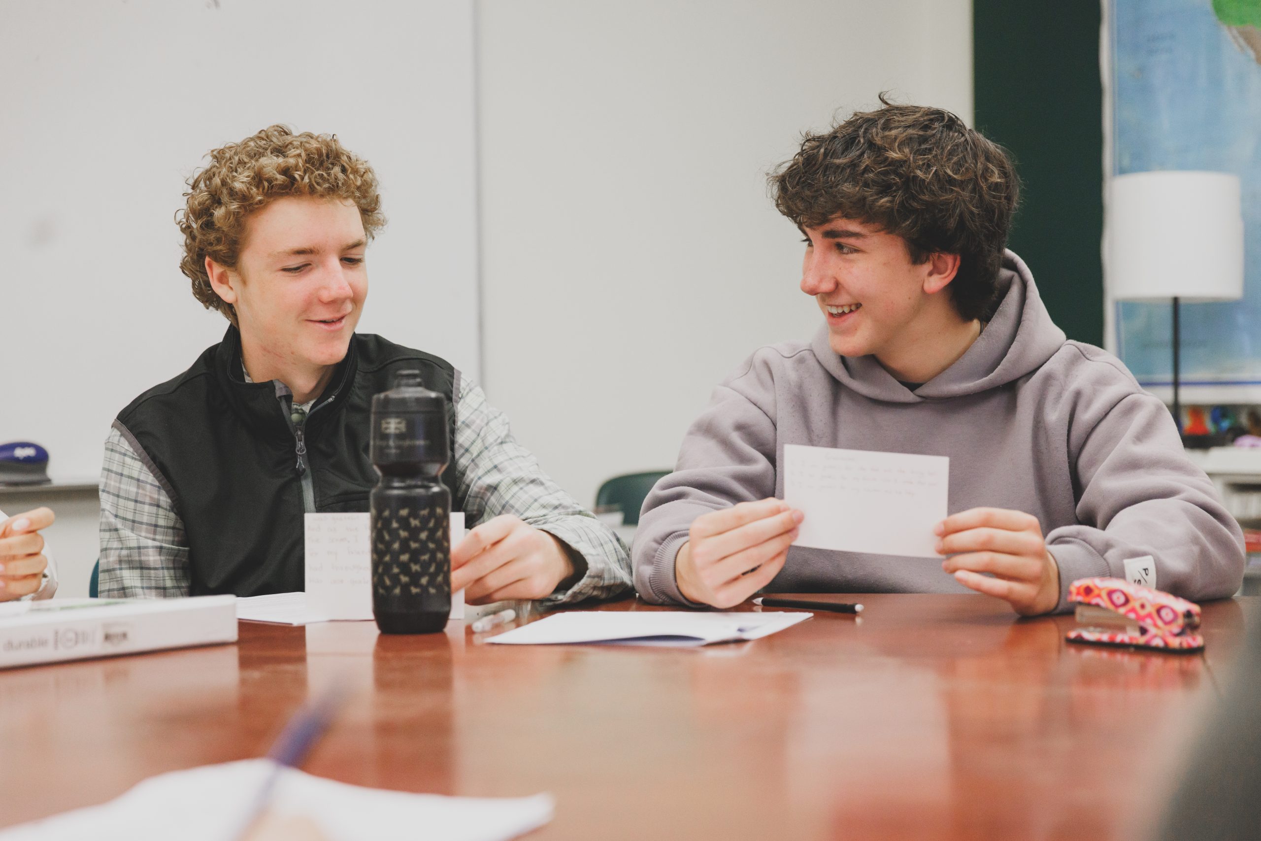 Two male students smiling in class