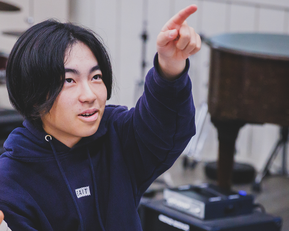 Student in class pointing to something.